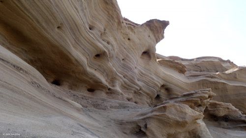 Vom Wind und Sand geformter Stein mit verschiedenen Bodenschichten